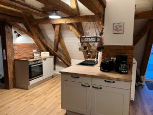 a kitchen with white cabinets and a brick wall at Der Moserhof in Oberaurach