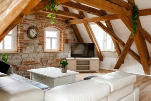 uma sala de estar com um sofá branco e uma televisão em Der Moserhof em Oberaurach