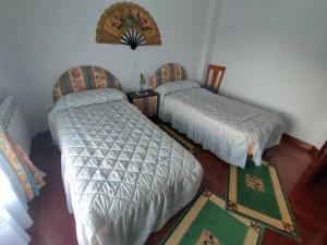 ein Schlafzimmer mit zwei Betten, einem Tisch und einem Teppich in der Unterkunft Vivienda de Uso Turístico en entorno maravilloso in Huerta del Rey