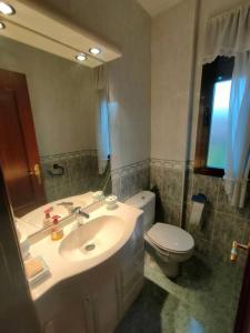 ein Badezimmer mit Waschbecken, Toilette und Spiegel in der Unterkunft Vivienda de Uso Turístico en entorno maravilloso in Huerta del Rey