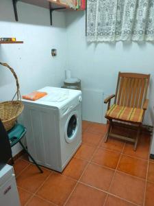 eine Waschmaschine und ein Stuhl in einem Zimmer in der Unterkunft Vivienda de Uso Turístico en entorno maravilloso in Huerta del Rey