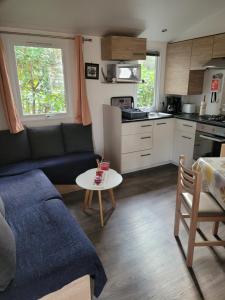 a living room with a couch and a table at Mobil home 6 personnes in Saint-Brevin-les-Pins