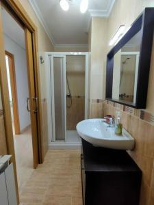 a bathroom with a white sink and a shower at Extraordinario ático de 80 m2 en urbaniz privada in Noja