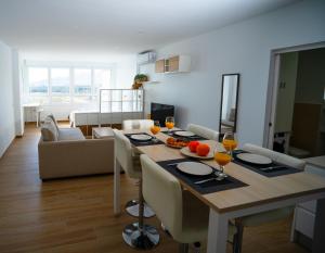 Sunstay Seaview Guadalmar في مالقة: غرفة طعام وغرفة معيشة مع طاولة وكراسي