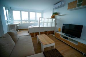 un soggiorno con divano e TV a schermo piatto di Sunstay Seaview Guadalmar a Málaga