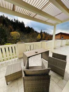 um pátio com uma mesa, cadeiras e uma cerca em Tanjas gemütliches Haus am Mondsee em Innerschwand