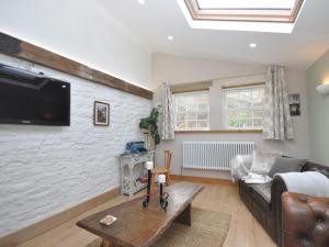 een woonkamer met een bank en een tv aan de muur bij 1 Bed in Cinderford 73633 in Longney