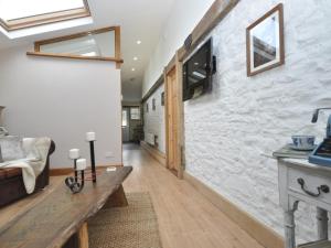 een woonkamer met een stenen muur en een houten tafel bij 1 Bed in Cinderford 73633 in Longney