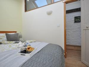 a bedroom with a bed with a tray of food on it at 1 Bed in Cinderford 73633 in Longney