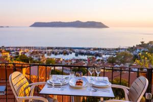 a table with wine glasses and a plate of food on a balcony at Luna Kaş in Kaş
