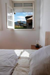 a bedroom with a white bed and a window at Moniz Terrace in Guimarães