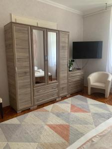 - une chambre avec une grande armoire en bois et une télévision dans l'établissement Szent István Apartman, à Makó