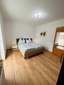 1 dormitorio con 1 cama y suelo de madera en Tanjas gemütliches Haus am Mondsee en Innerschwand