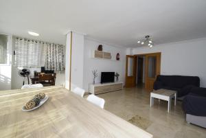 a living room with a table and a couch at Pintor Rosales 3 dormitorios mirando al mar - Fincas Arena in Benidorm