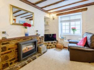 - un salon avec une cheminée et un canapé dans l'établissement 3 Bed in Ilfracombe 57795, à Ilfracombe