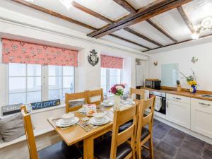 Il comprend une cuisine et une salle à manger avec une table et des chaises en bois. dans l'établissement 3 Bed in Ilfracombe 57795, à Ilfracombe