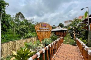 a wooden walkway in a garden with a fence at Rizky Bromo Homestay in Lambangkuning