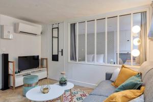 - un salon avec un canapé et une télévision dans l'établissement Appartement proche Arc Triomphe 4P, à Paris