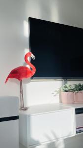 a red flamingo standing on a table next to a tv at ApartmentInCopenhagen Apartment 1590 in Copenhagen
