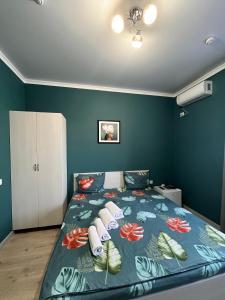 - une chambre dotée d'un lit avec un mur bleu dans l'établissement Мини-гостиница Береке, à Aqtöbe