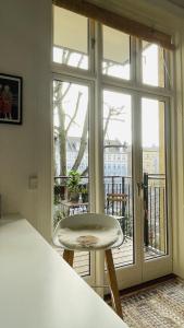 a white stool in front of a large window at ApartmentInCopenhagen Apartment 1590 in Copenhagen
