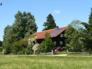 a large black house with a red roof at Ferienhof Hiemer in Sulzberg
