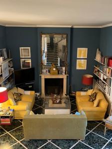 a living room with yellow couches and a mirror at artemare in Viareggio