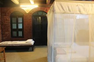 Konkan Nest Resort في غانباتيبول: غرفة بسرير ونافذة مع ستارة