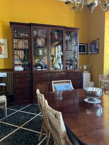une salle à manger avec une table en bois et une armoire en porcelaine dans l'établissement artemare, à Viareggio