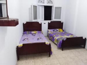 1 dormitorio con 2 camas y ventana en El Nahass Villa, en Ras El Bar