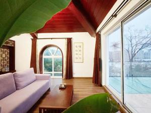 un soggiorno con divano e una grande finestra di Zen of Tiger Luxury garden villa with sea view大理老虎的觉后禅独栋海景花园别墅 a Dali