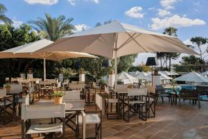 un ristorante con tavoli, sedie e ombrelloni di Prinsotel Mal Pas a Alcudia