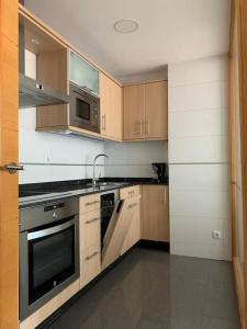 a kitchen with wooden cabinets and a stove top oven at Acogedor piso céntrico in Lugo