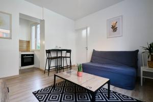 a living room with a blue couch and a table at Quiet one-bedroom flat close to the metro in Lille