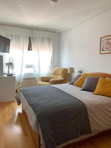 1 dormitorio con 1 cama grande y 1 silla en Acogedor piso céntrico, en Lugo