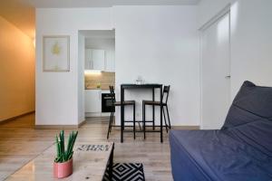 a living room with a couch and a table at Quiet one-bedroom flat close to the metro in Lille
