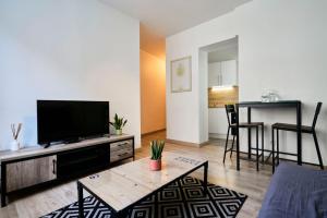 a living room with a television and a table at Quiet one-bedroom flat close to the metro in Lille