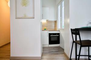 a kitchen with white cabinets and a black oven at Quiet one-bedroom flat close to the metro in Lille +16 photos