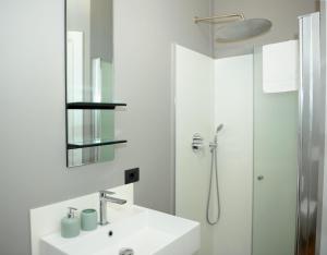 y baño blanco con lavabo y ducha. en Ca’ Bruno Masaneta en Grado