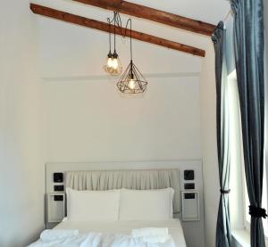 una camera con un letto bianco e due luci di Ca’ Bruno Masaneta a Grado