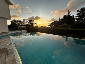 a swimming pool with a sunset in the background at Sea View villa w infinity pool in Tala