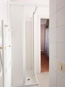 a glass shower door in a white bathroom at appartamento teatro marcello in Rome