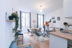 een keuken en een woonkamer met een tafel en stoelen bij Splendide appartement proche Opéra Garnier - 6P in Parijs