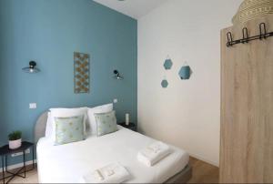 ein Schlafzimmer mit einem weißen Bett mit blauen Wänden in der Unterkunft Splendide appartement proche Opéra Garnier - 6P in Paris