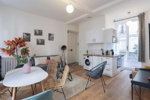ein Wohnzimmer mit einem Tisch und Stühlen sowie eine Küche in der Unterkunft Splendide appartement proche Opéra Garnier - 6P in Paris