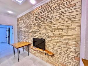 a stone wall with a tv and a table at Zen house in Kas
