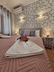 a bedroom with a large bed with a flower on it at Kiki's Apartments in Barbati