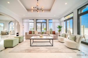 a living room with couches and a table at Seaside 5BR Villa with Assistant's Room and Beach Access on Palm Jumeirah by Deluxe Holiday Homes in Dubai