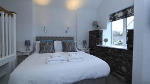 1 dormitorio con 1 cama blanca grande y toallas. en Braithwaite House Rooms en Braithwaite