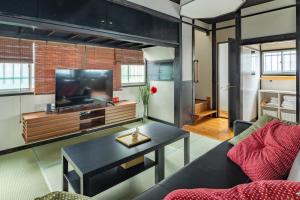a living room with a couch and a tv at SKY GATEスカイツリー徒歩3分の貸切ヴィラ/成田羽田直通/浅草徒歩15分 in Tokyo